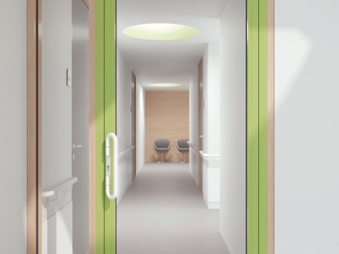 Porte d'hôpital vitrée avec cadre vert équipée d'une poignée de couleur blanc de sécurité en polyamide