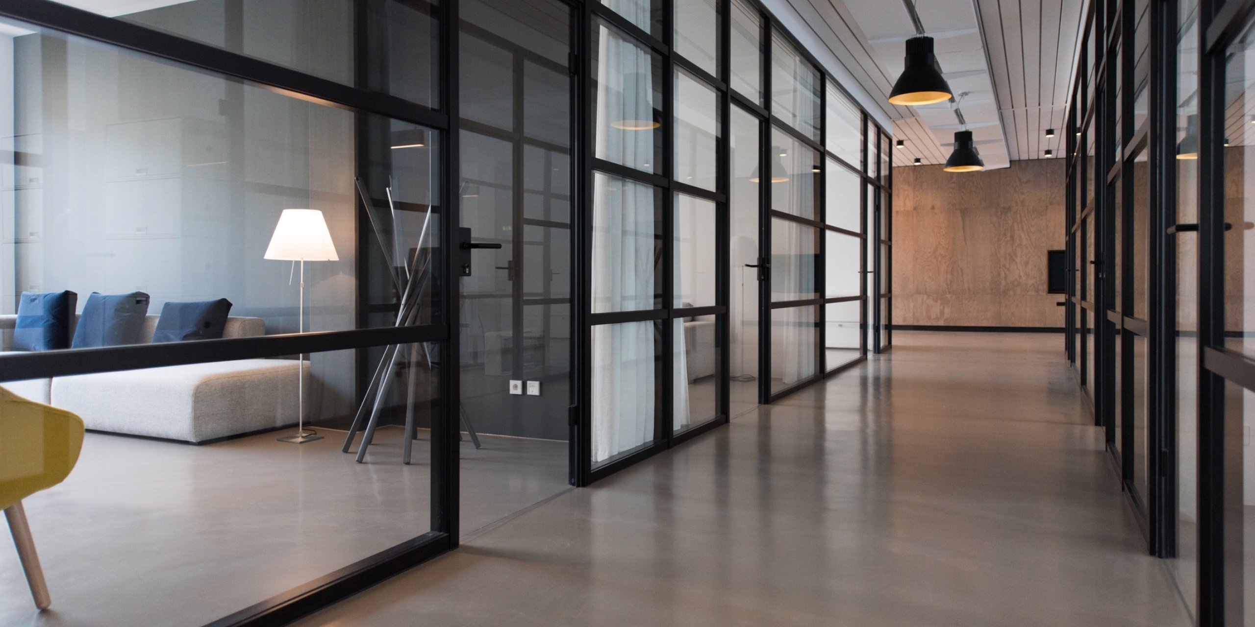 Corridor in an office building with transparent doors to various offices